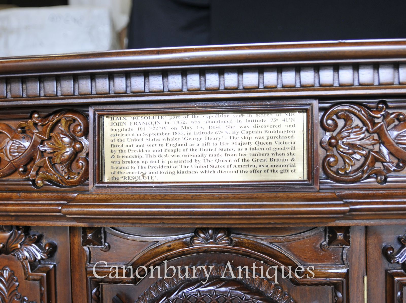 Close up of the bronze inscribed plaque on the back of the desk